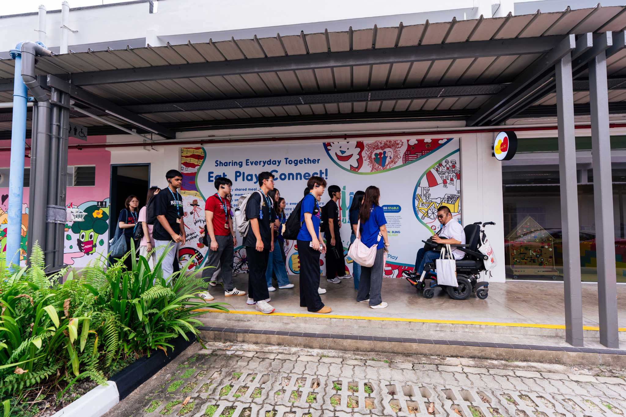 Student delegates tour Enabling Village to learn about inclusive spaces and initiatives that support persons with disabilities.